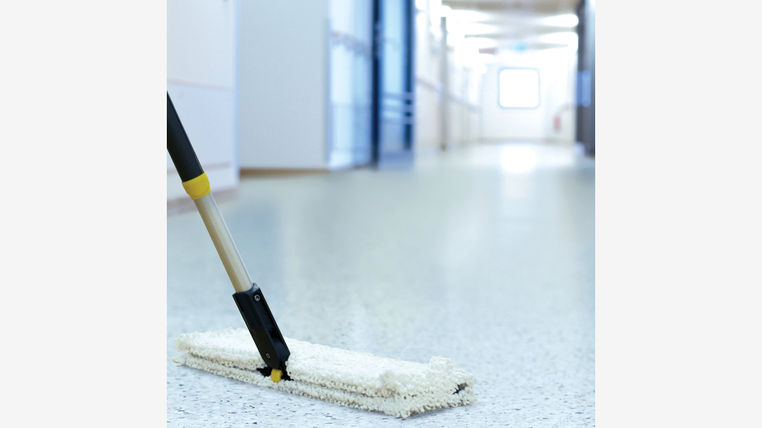 Mop cleans the floor in a Long corridor