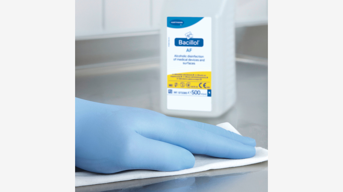 Hand in glove wipes / disinfects a surface with a wipe