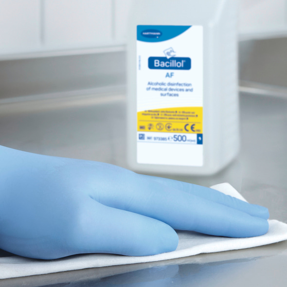 Hand in glove wipes / disinfects a surface with a wipe